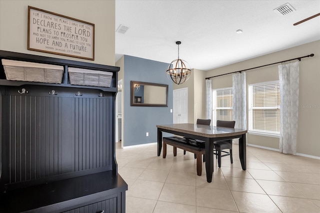 tiled dining space featuring ceiling fan with notable chandelier