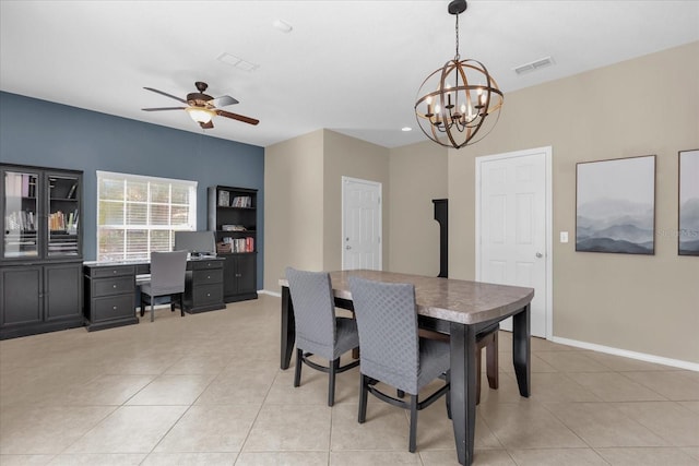 tiled dining space featuring ceiling fan with notable chandelier