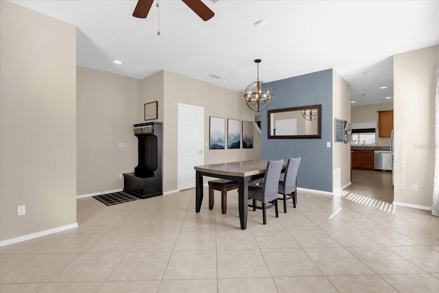 tiled dining area with ceiling fan with notable chandelier and sink