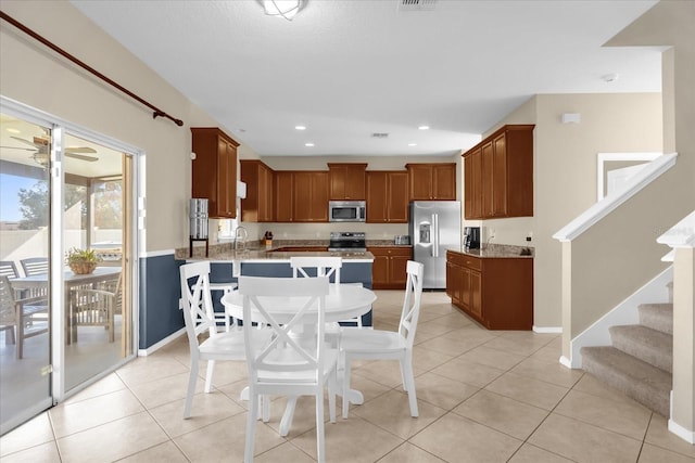 dining room featuring light tile patterned floors, ceiling fan, and sink