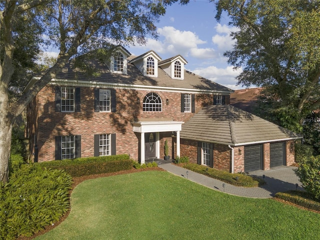 colonial home featuring a front lawn and a garage