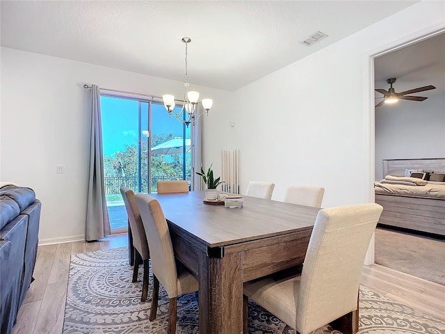 dining space featuring ceiling fan with notable chandelier and light wood-type flooring