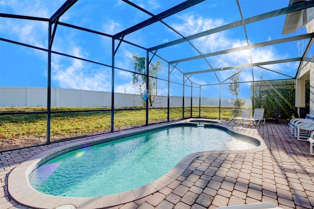 view of pool featuring a patio, glass enclosure, and an in ground hot tub