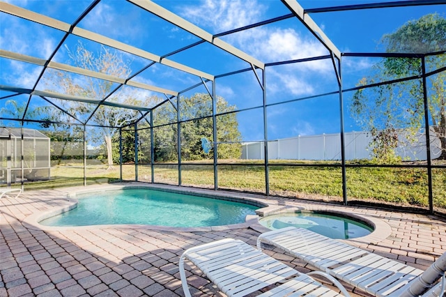 view of swimming pool with an in ground hot tub, a lanai, a lawn, and a patio area