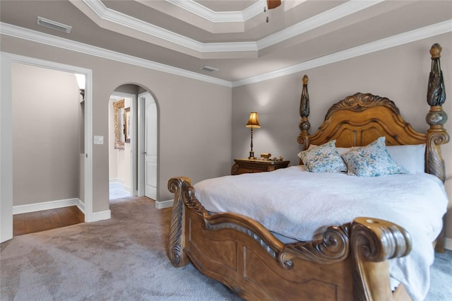 bedroom with a tray ceiling, crown molding, carpet floors, and ceiling fan