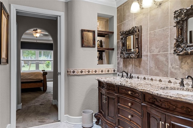 bathroom with crown molding, vanity, and ceiling fan