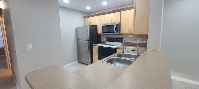 kitchen with light brown cabinetry, sink, appliances with stainless steel finishes, kitchen peninsula, and decorative backsplash