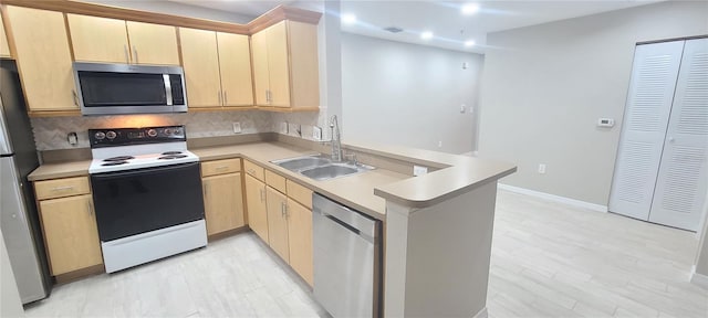 kitchen with appliances with stainless steel finishes, light brown cabinetry, sink, decorative backsplash, and kitchen peninsula