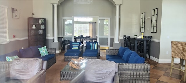 living room featuring a high ceiling and ornate columns