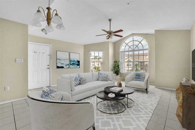 living room featuring vaulted ceiling, light tile patterned floors, and ceiling fan with notable chandelier