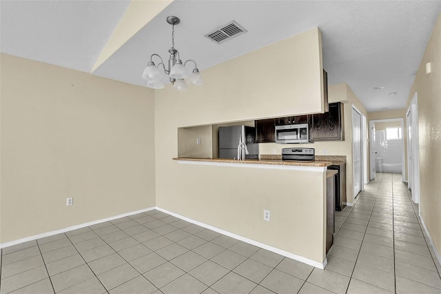 kitchen featuring dark brown cabinetry, stainless steel appliances, kitchen peninsula, a chandelier, and light tile patterned flooring