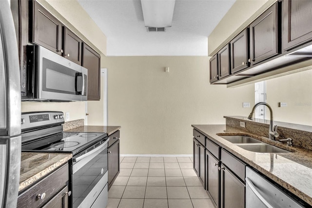 kitchen featuring light tile patterned floors, sink, dark brown cabinetry, and appliances with stainless steel finishes