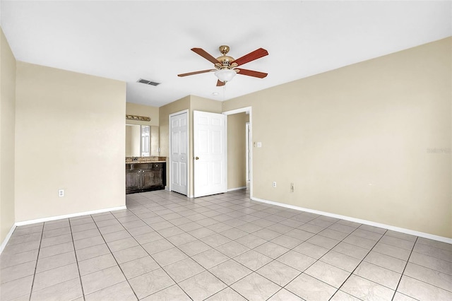 unfurnished room with ceiling fan and light tile patterned floors