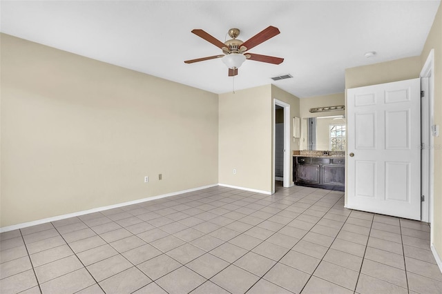 spare room with ceiling fan and light tile patterned flooring