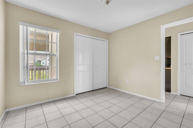 unfurnished bedroom featuring a closet and light tile patterned flooring