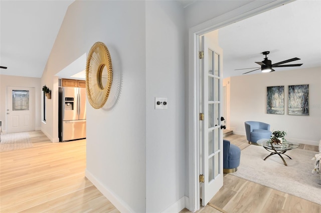 hallway with vaulted ceiling and light hardwood / wood-style floors