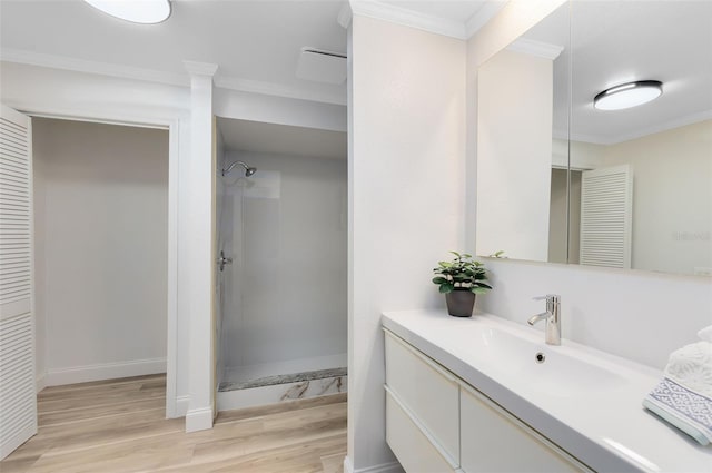 bathroom featuring a shower, crown molding, wood-type flooring, and vanity