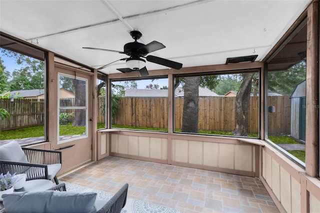 unfurnished sunroom featuring ceiling fan