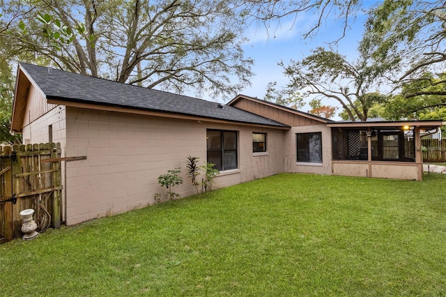 back of property featuring a sunroom and a yard