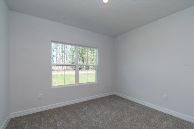 carpeted spare room featuring baseboards