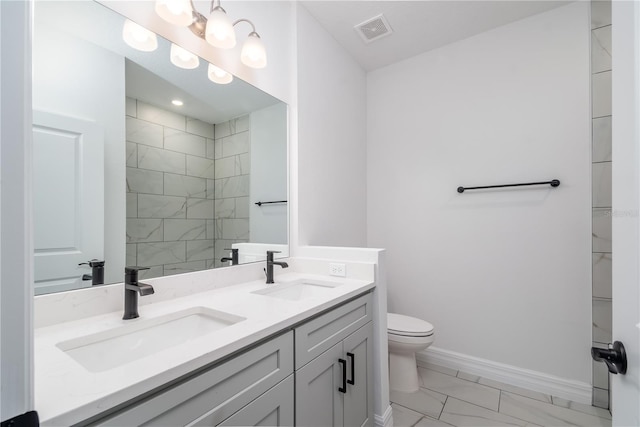 full bathroom with toilet, double vanity, a sink, and visible vents