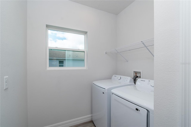 clothes washing area with laundry area, separate washer and dryer, and baseboards