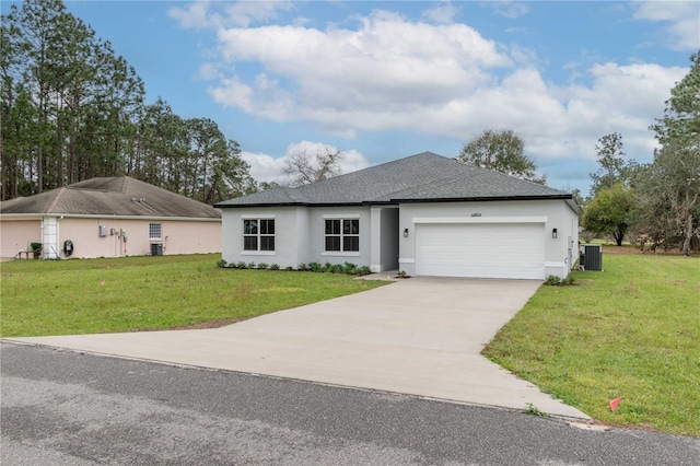 single story home featuring a garage, concrete driveway, central AC unit, and a front yard