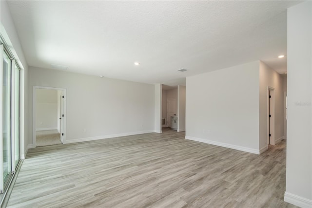 unfurnished room featuring recessed lighting, light wood-style flooring, and baseboards