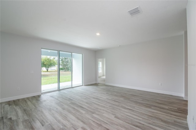 unfurnished room featuring recessed lighting, light wood-type flooring, visible vents, and baseboards