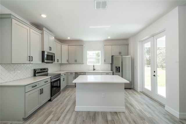 kitchen with tasteful backsplash, visible vents, stainless steel appliances, french doors, and a sink