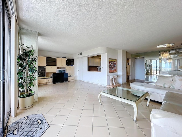 living room featuring light tile patterned flooring, an inviting chandelier, and a textured ceiling