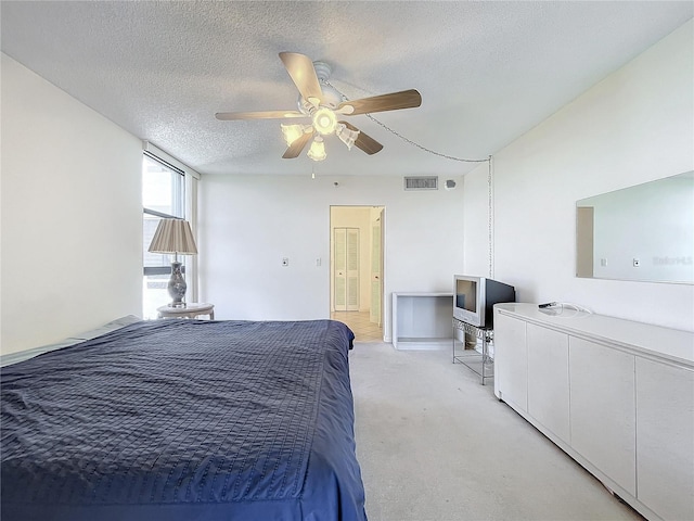 carpeted bedroom with a textured ceiling and ceiling fan