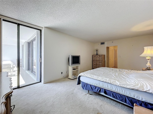 carpeted bedroom featuring access to outside and a textured ceiling