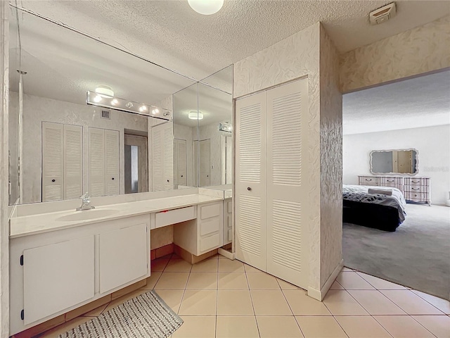 bathroom featuring a textured ceiling, tile patterned flooring, and vanity