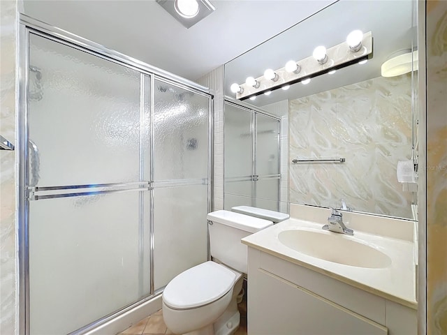 bathroom with a shower with door, tile patterned floors, vanity, and toilet