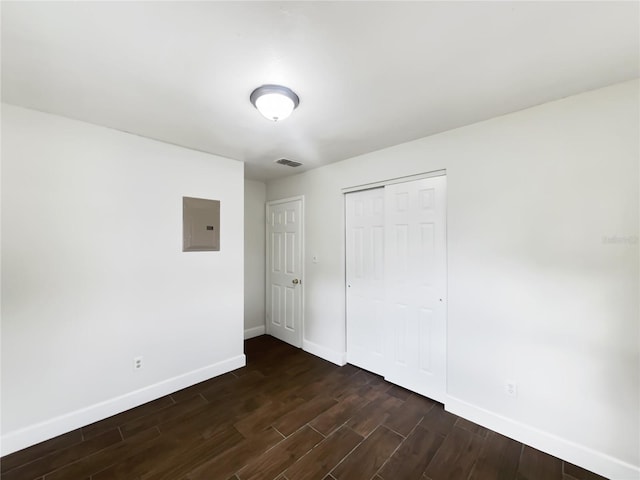 unfurnished bedroom featuring electric panel and a closet