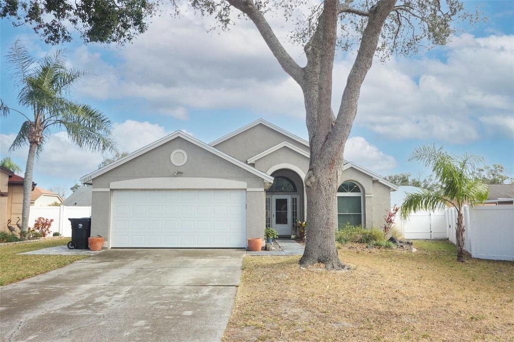 ranch-style house featuring a front yard and a garage