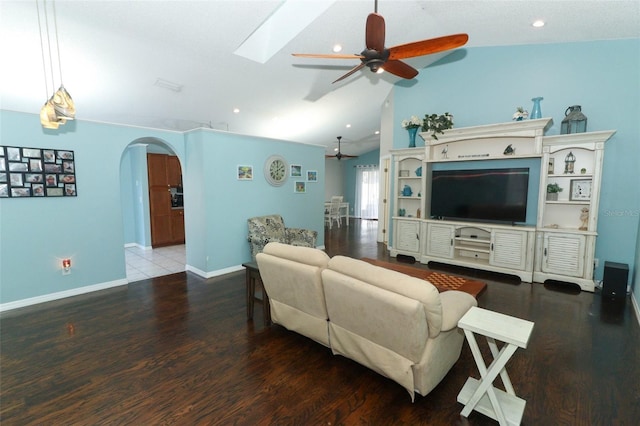 living room with hardwood / wood-style flooring, lofted ceiling with skylight, and ceiling fan