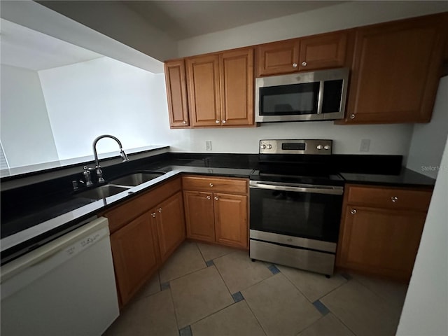 kitchen with light tile patterned flooring, stainless steel appliances, and sink