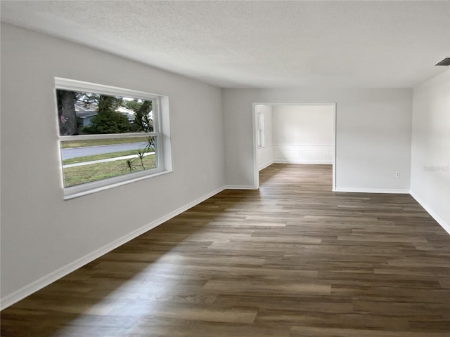 empty room featuring dark hardwood / wood-style flooring and a textured ceiling