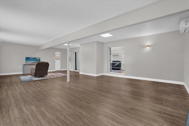 basement featuring a wall unit AC and hardwood / wood-style flooring