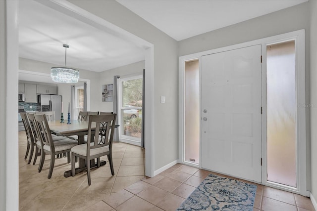 tiled dining room with a chandelier