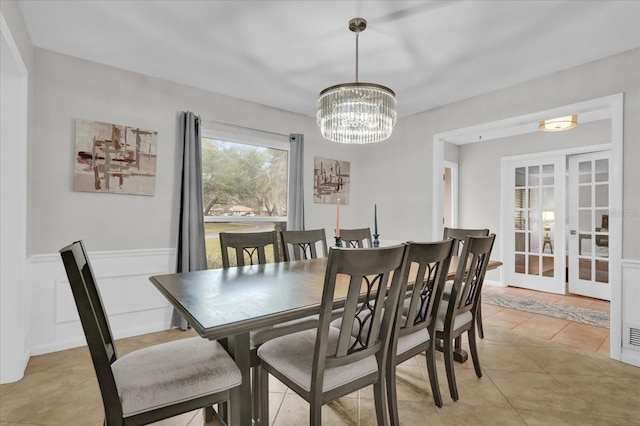 tiled dining area with an inviting chandelier and french doors