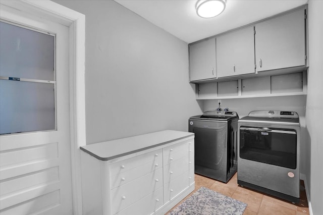 laundry area featuring light tile patterned floors, cabinets, and independent washer and dryer