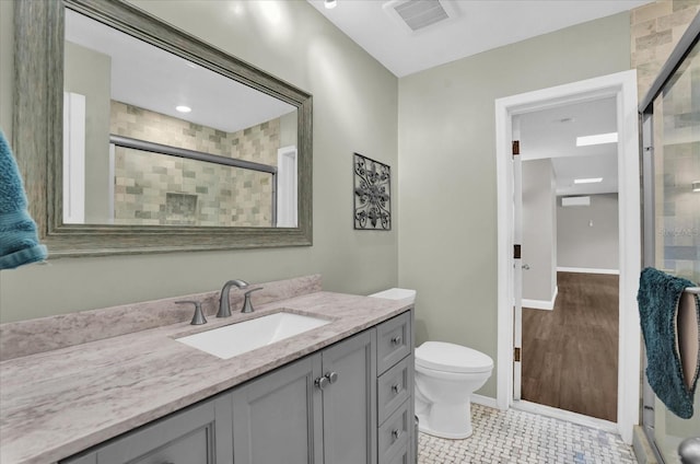 bathroom featuring toilet, tile patterned flooring, an enclosed shower, and vanity