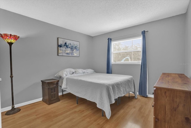 bedroom featuring a textured ceiling and light hardwood / wood-style floors