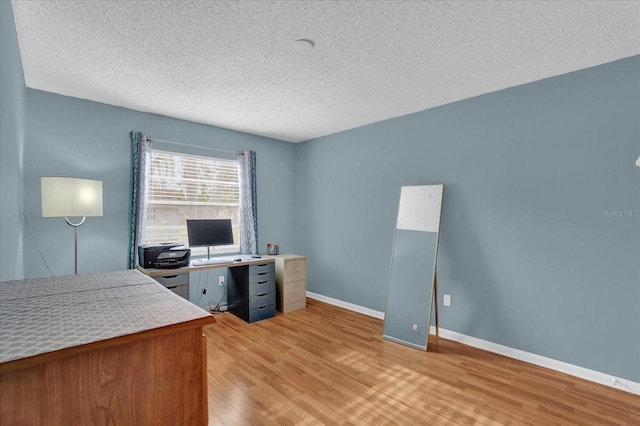 office area featuring light wood-type flooring and a textured ceiling