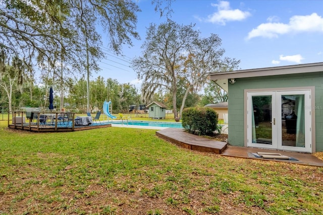 view of yard featuring french doors and a pool side deck