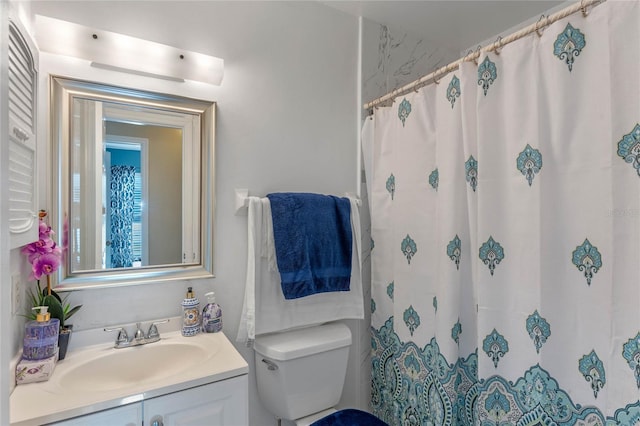 bathroom featuring vanity, toilet, and walk in shower