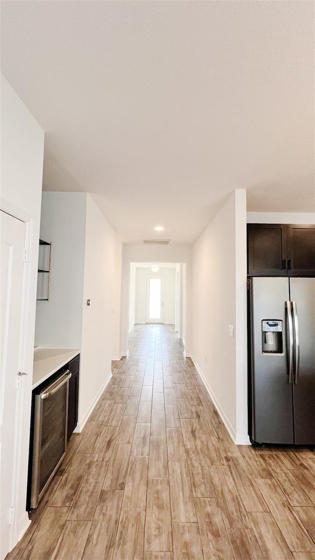 kitchen with wine cooler, stainless steel refrigerator with ice dispenser, and dark brown cabinets